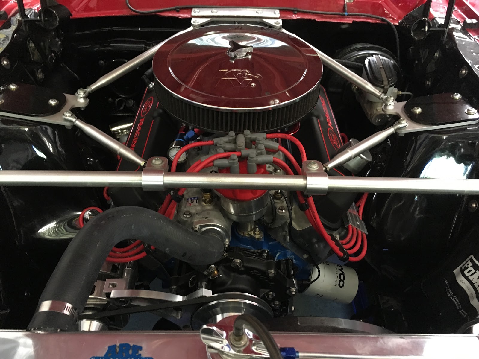 The engine bay of a restored red V8, rebuilt and detailed