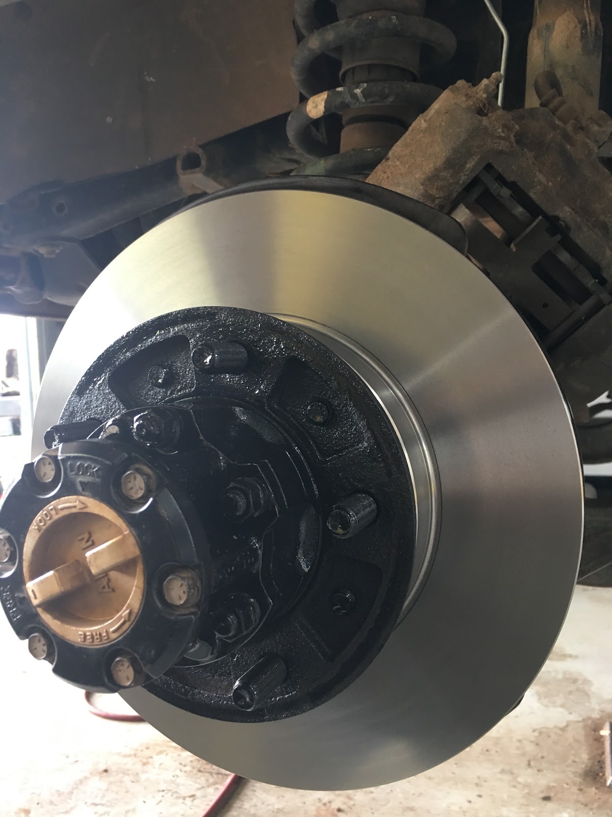 Machined front brake disc and hub with the caliper hung clear, on a four wheel drive