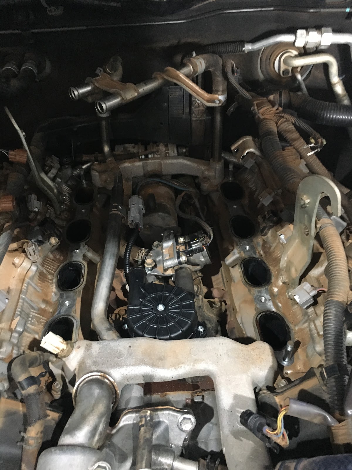Intake manifold lifted off a V6, ports and injectors exposed